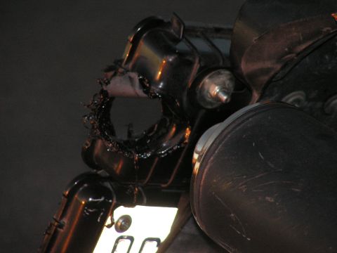 1994 Ford Bronco - Close-up of a damaged plastic component with exposed wiring, possibly from a vehicle's undercarriage.