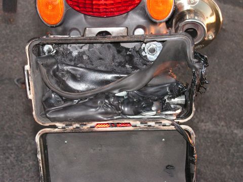 1994 Ford Bronco - Damaged electrical component within a vehicle's storage box, showing signs of heat damage.