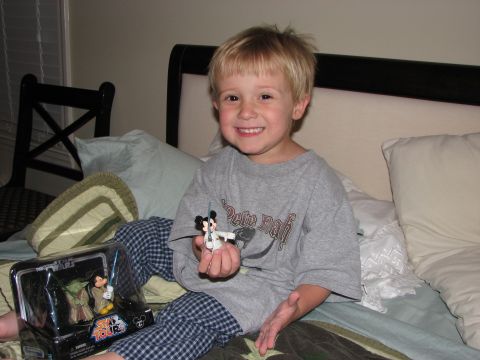 1991 Ford Bronco - A young child sits on a bed, smiling and holding toys.