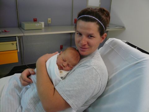 1996 Ford Probe - A woman cradles her newborn baby, both appearing comfortable in a hospital setting.