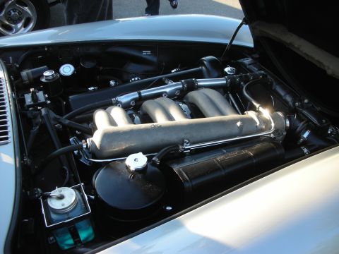 1998 Ford Crown Victoria - Open engine bay of a silver sports car showing a polished velocity-stack intake manifold and chrome plumbing.