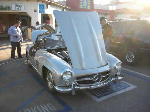 1998 Ford Crown Victoria - Silver Mercedes-Benz convertible with its hood raised, parked outside a storefront at a morning car meet.