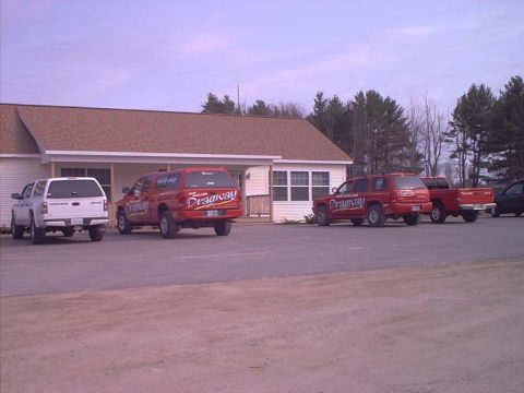 2000 Ford Crown Victoria - Multiple red SUVs and a white pickup truck are parked in front of a building with 'Dragway' graphics on the vehicles.