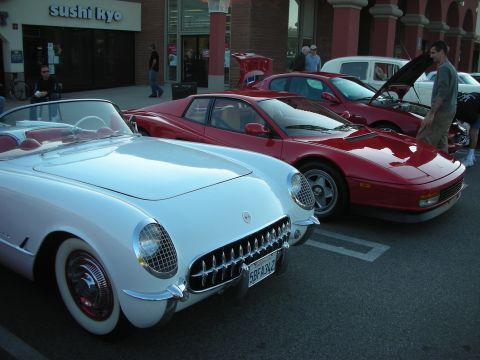 1998 Ford Crown Victoria - White vintage Corvette parked nose-to-nose with a red Ferrari Testarossa outside a sushi restaurant.