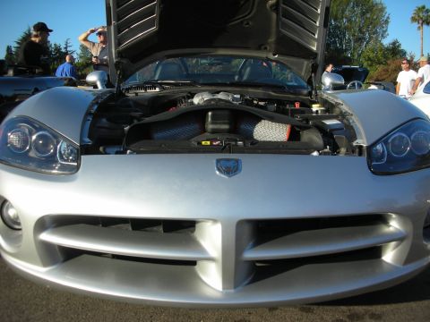 1998 Ford Crown Victoria - Silver Dodge Viper with hood raised, its ram's-head badge and engine bay visible at an outdoor car meet.