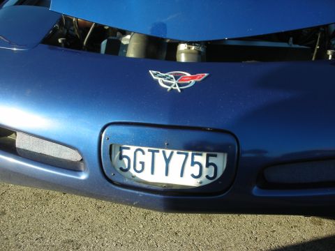 1998 Ford Crown Victoria - Front of a blue C5 Corvette showing the crossed-flags emblem and a California plate reading 5GTY755.