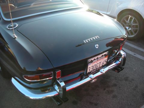 1998 Ford Crown Victoria - Rear deck of a dark Ferrari coupe showing its script badge and a black California plate reading 3306165.