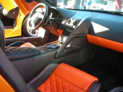 1998 Ford Crown Victoria - Interior of a Lamborghini showing the black dashboard, console badge and orange diamond-stitched leather seats.