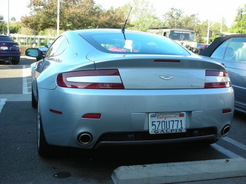 1998 Ford Crown Victoria - Rear of a silver Aston Martin Vantage coupe showing the winged badge and a California Galpin plate reading 5ZOU771.