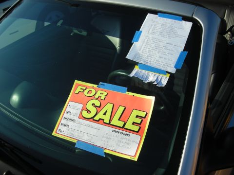 1998 Ford Crown Victoria - bright FOR SALE sign and a handwritten specification sheet taped to the windshield of a dark car.