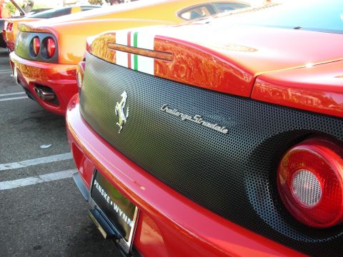 1998 Ford Crown Victoria - Rear of a red Ferrari 360 Challenge Stradale with prancing-horse badge, Italian tricolor stripe, and a Penske Wynn plate frame.