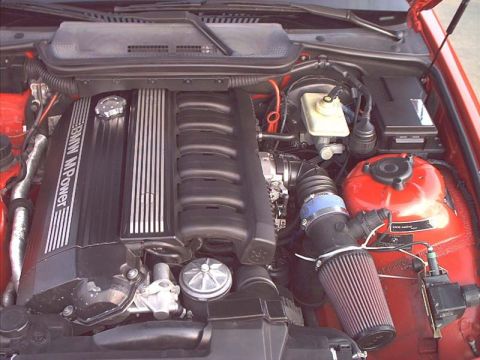 2000 Ford Crown Victoria - Close-up view of a BMW M Power engine, a custom air intake system and red valve cover.
