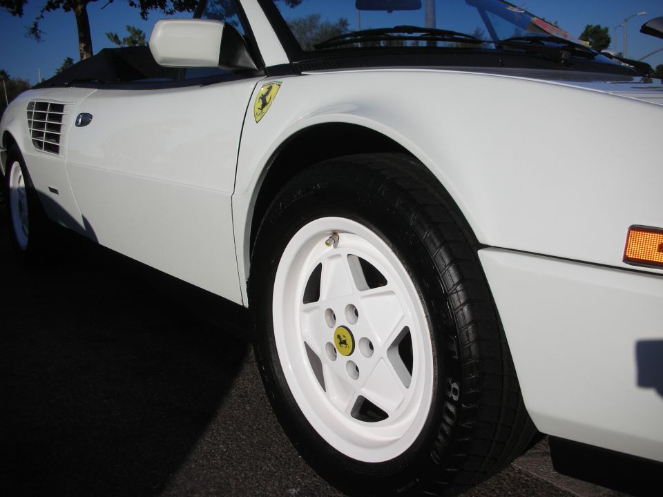 White Ferrari front fender shield and white wheel with yellow Ferrari cap
