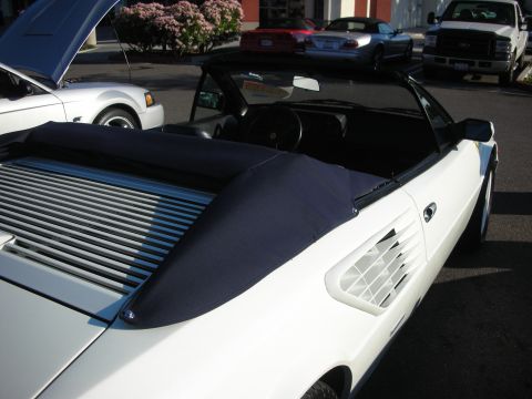 1998 Ford Crown Victoria - Top-down view into a white Ferrari Mondial convertible showing the cockpit and a navy soft-top tonneau boot.