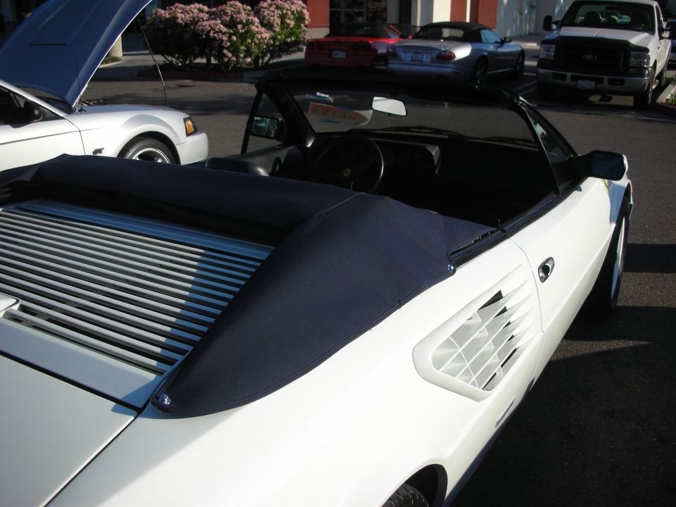 White Ferrari Mondial convertible from above with navy soft-top boot