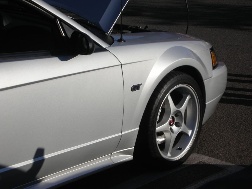 Silver Ford Mustang front fender with GT badge and five-spoke wheel