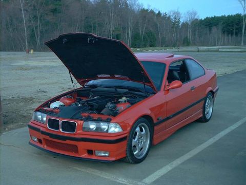 2000 Ford Crown Victoria - Red BMW E36 coupe with hood open, parked outdoors.