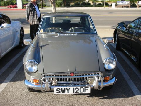 1998 Ford Crown Victoria - gray MG coupe with a chrome octagon-badge grille and a UK plate reading SWY 120F is parked facing the camera at a meet.
