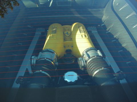 1998 Ford Crown Victoria - yellow-crackle Ferrari V8 intake sits beneath a glass engine cover with red defroster lines, flanked by silver air boxes.
