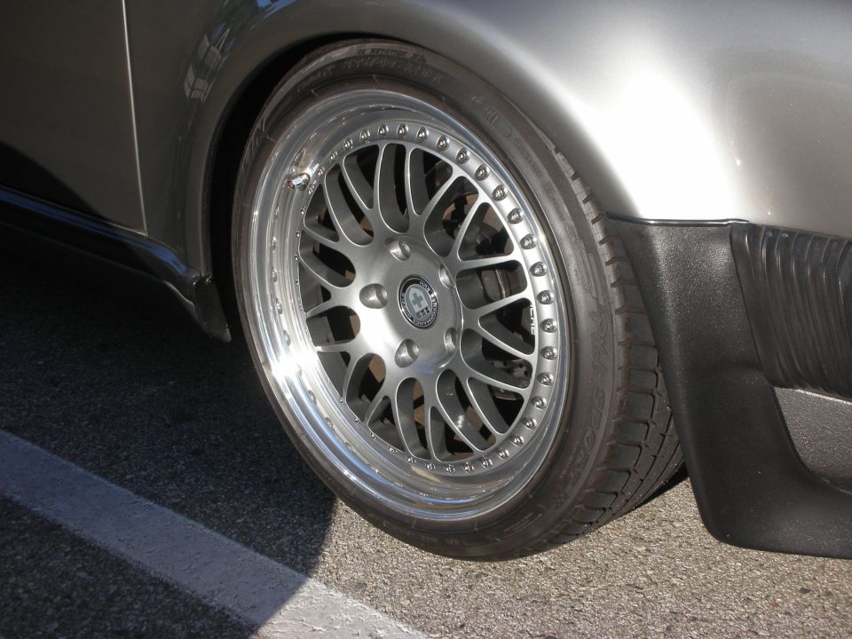 Close-up of a polished multi-spoke wheel on a silver-gray car