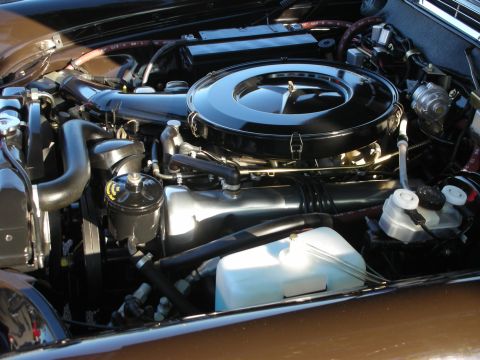 1998 Ford Crown Victoria - detailed V8 engine bay shows a large black air cleaner with a Mercedes three-pointed-star lid and a clear coolant tank.