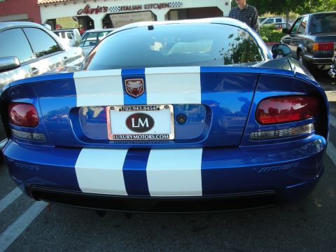 1998 Ford Crown Victoria - Rear view of a blue Dodge Viper coupe with white racing stripes, ram-head badge and a LuxuryMotors dealer plate frame.