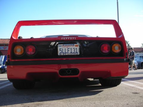 1998 Ford Crown Victoria - Head-on rear view of a red Ferrari F40 with its high rear wing, twin round tail lights and a California license plate.