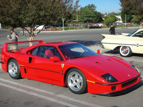 1998 Ford Crown Victoria - red Ferrari F40 shown in side profile with its rear wing and five-spool wheels, beside a cream-colored classic car.