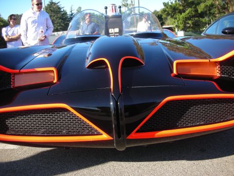 1998 Ford Crown Victoria - Close head-on view of a black Batmobile replica's scalloped nose with orange-red trim and dual mesh grilles.