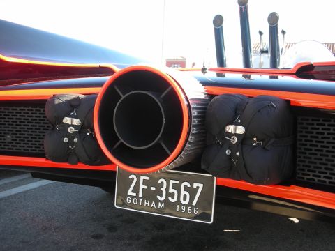 1998 Ford Crown Victoria - Close-up of a black and red vehicle's rear featuring a large turbine-style exhaust nozzle, twin pipes, and a black license plate reading 2F…