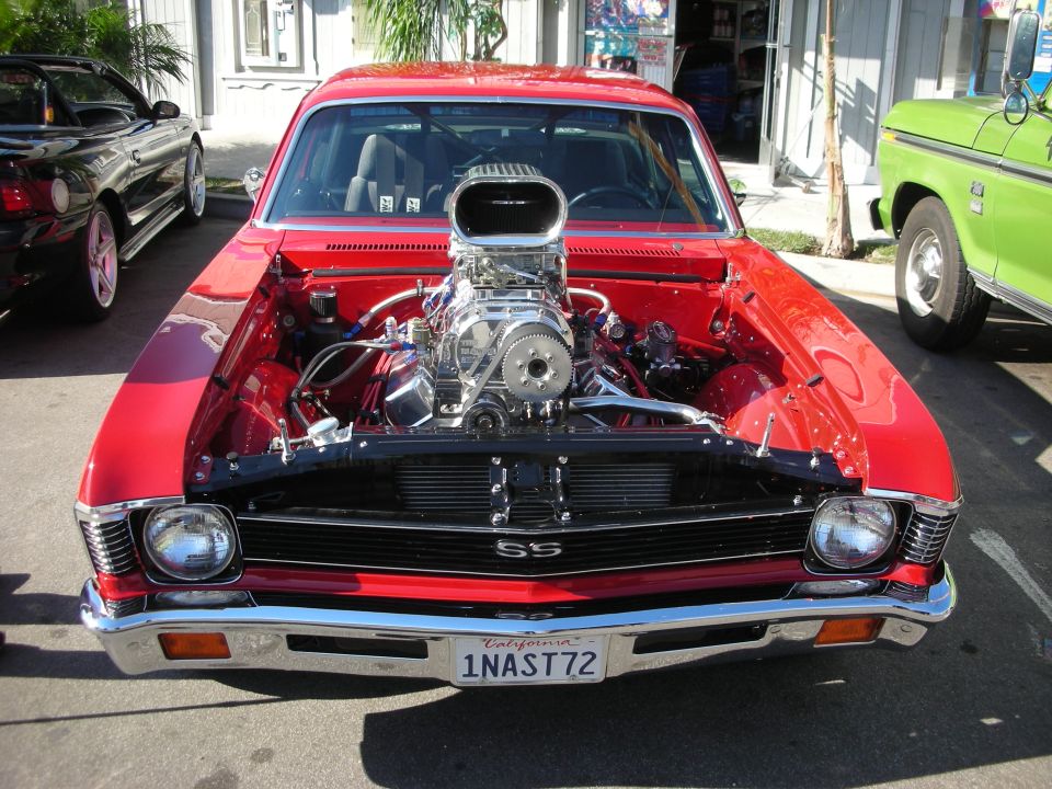 Red Chevy Nova SS with exposed blower engine and plate 1NAST72