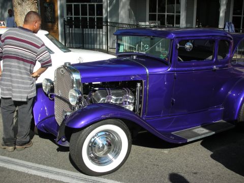 1998 Ford Crown Victoria - Custom purple hot rod on display, with another vehicle partially visible in the background.