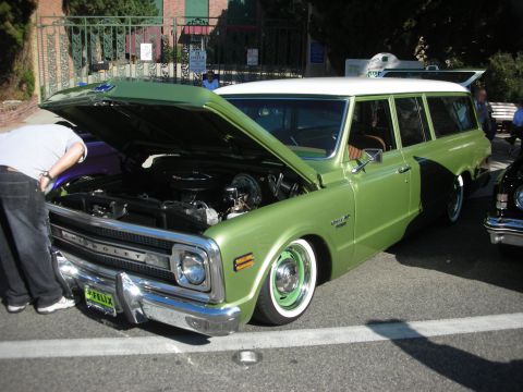 1998 Ford Crown Victoria - Green 1970 Chevrolet station wagon at a show, hood open. Whitewall tires with green rims visible.