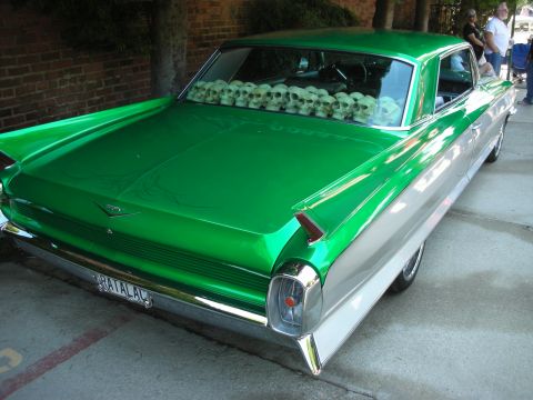 1998 Ford Crown Victoria - This custom two-tone green and silver car features a unique display of skulls in its rear window and a personalized license plate.
