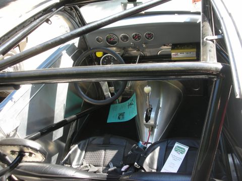 1998 Ford Crown Victoria - The interior of a modified vehicle features racing seats, a roll cage, and multiple gauges on the dashboard.
