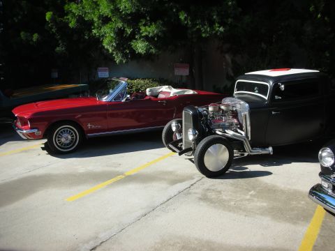 1998 Ford Crown Victoria - Two classic cars, a hot rod and a convertible, parked side-by-side.