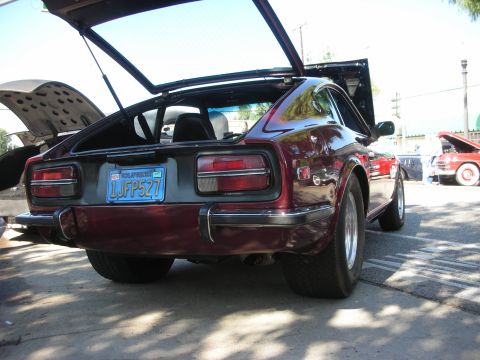 1998 Ford Crown Victoria - A maroon Datsun 240Z is parked with its hood and hatch open, showing another car in the background.