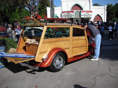 1998 Ford Crown Victoria - A classic woodie station wagon is displayed with surfboards on its roof and hats in its open tailgate.