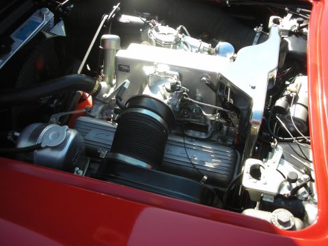 1998 Ford Crown Victoria - The engine bay of a red vehicle is shown, a V8 engine with chrome accents and a large air intake system.
