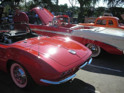 1998 Ford Crown Victoria - Multiple classic cars are parked outdoors, including a red convertible sports car in the foreground.
