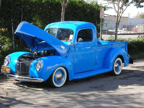 1998 Ford Crown Victoria - This bright blue pickup truck from the 1940s is displayed with its hood open, revealing the engine and chrome details.
