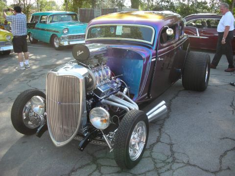 1998 Ford Crown Victoria - A custom hot rod with a prominent engine and unique paint job is parked outdoors.