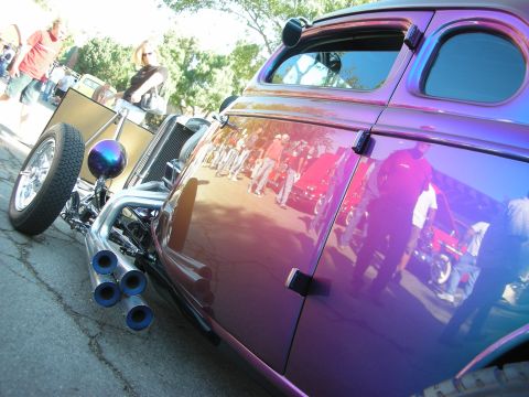 1998 Ford Crown Victoria - Custom hot rod with iridescent purple paint and quad exhaust pipes at a car show.