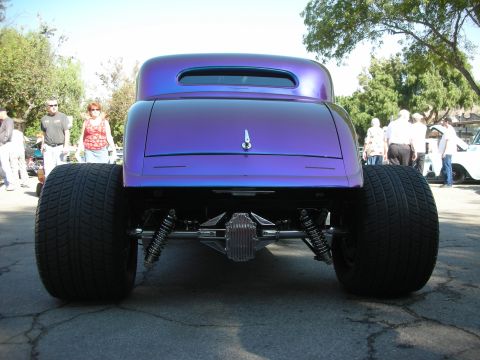 1998 Ford Crown Victoria - A custom hot rod with a unique purple paint job is parked outdoors with people in the background.