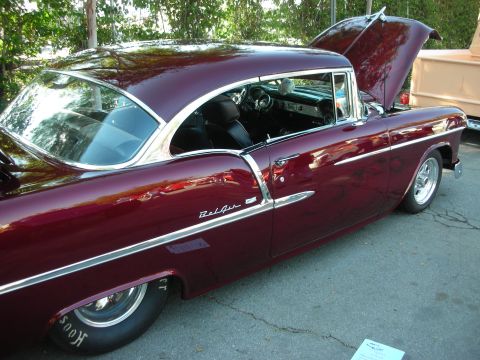 1998 Ford Crown Victoria - This maroon 1955 Chevrolet Bel Air features a classic design with its hood open, revealing the interior and gleaming chrome accents.