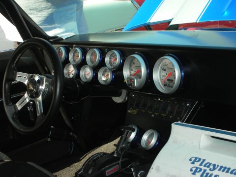 1998 Ford Crown Victoria - The interior features a custom dashboard filled with gauges and a racing shifter, alongside a cooler with visible text.