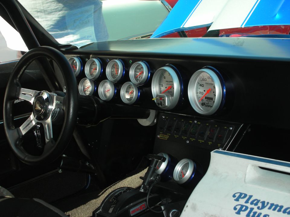 Custom dashboard with many Auto Meter gauges, steering wheel and toggle switches