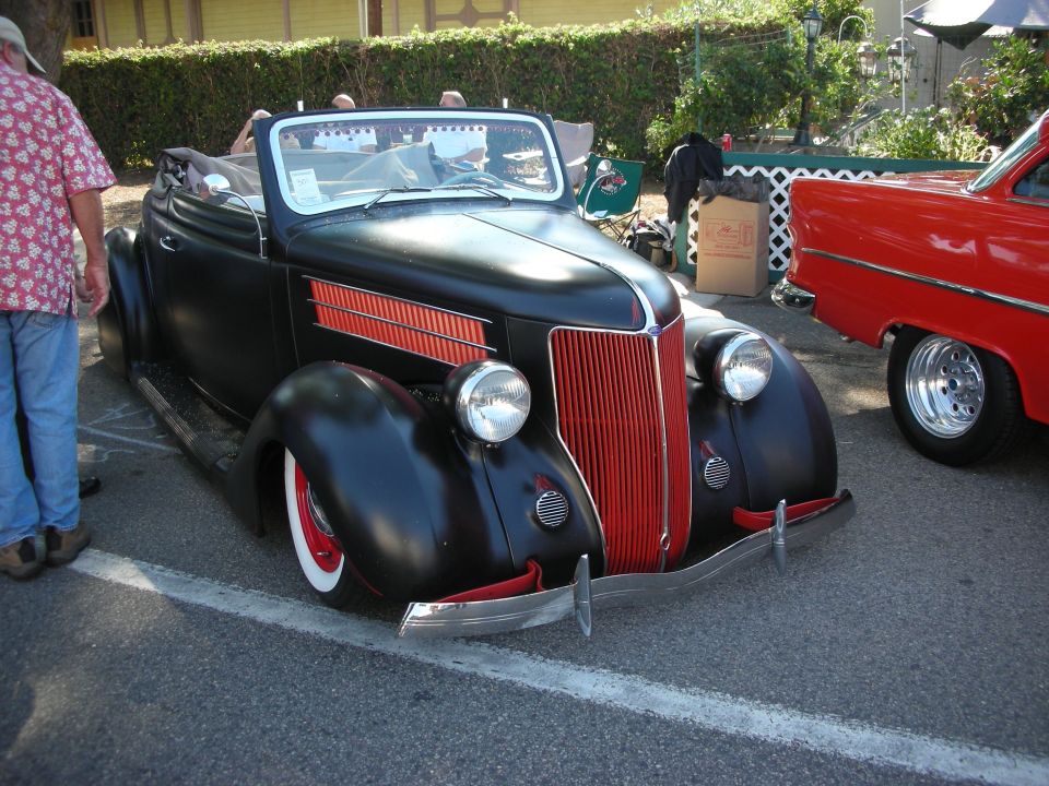 Black and red 1930s convertible hot rod at outdoor car show