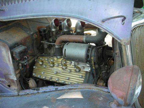 1998 Ford Crown Victoria - Custom V8 engine with triple carburetors and gold valve covers, part of a modified vehicle.