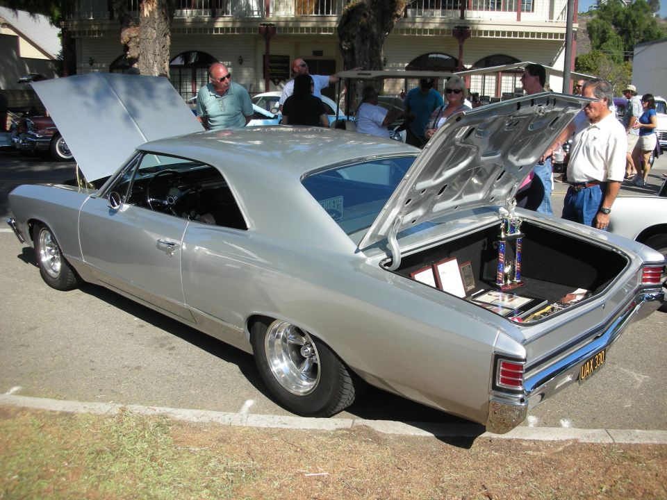 Silver 1967 Chevrolet Chevelle with open hood and trunk at car show